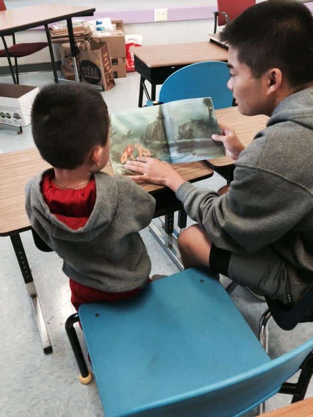 Young man reading to a small boy