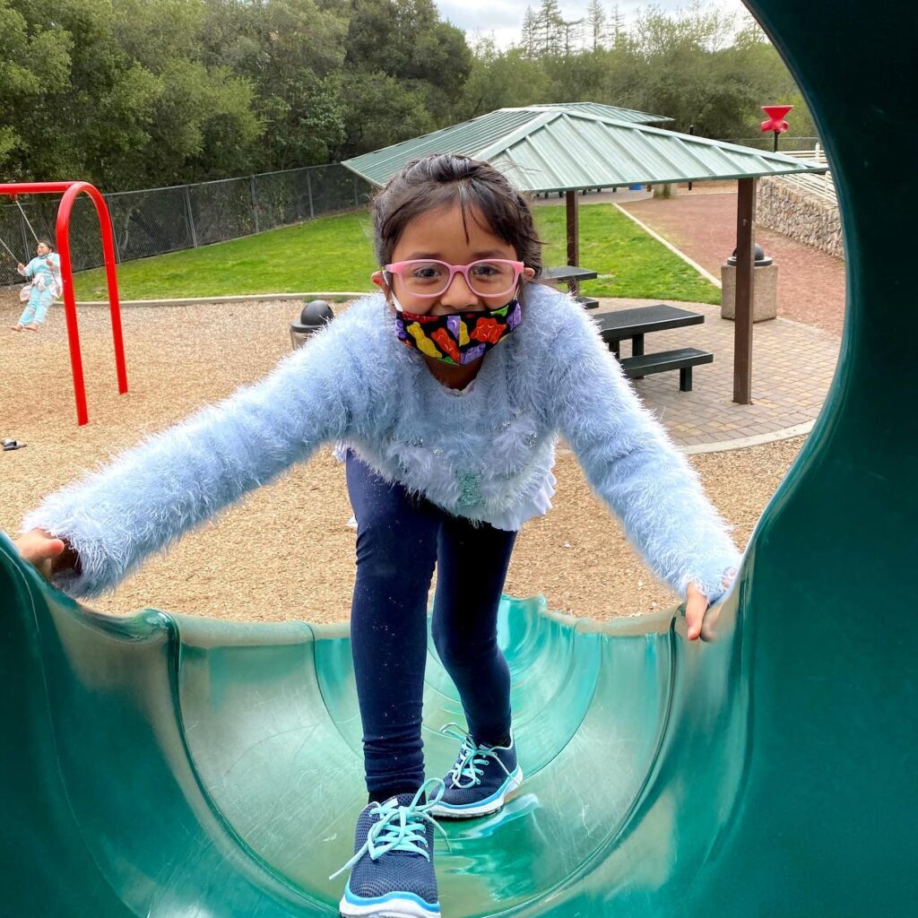 Young girl climbing up a slide