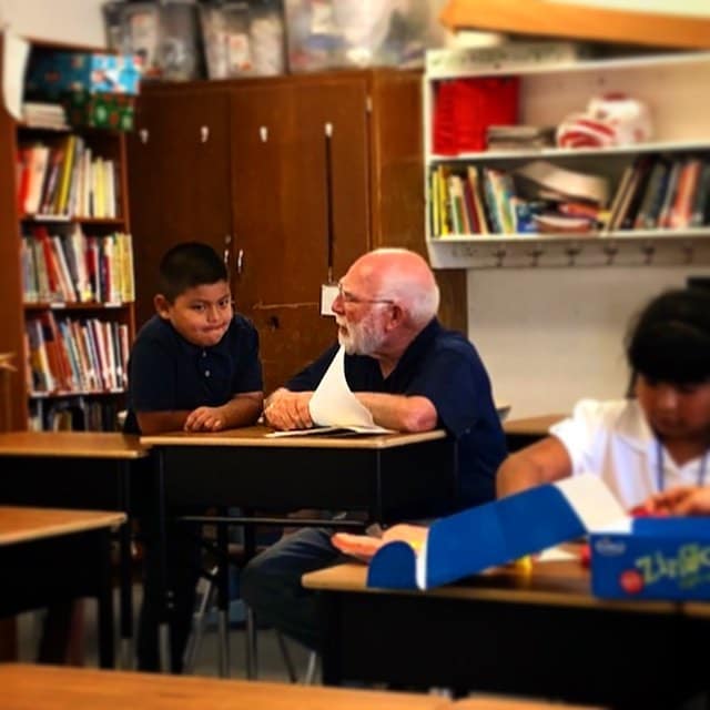 An older man and young boy reading